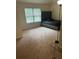 Comfortable bedroom with a sleek bed frame, plush carpeting, and a bright window, creating a serene space at 1749 Misselthrush Ln, Mcdonough, GA 30253
