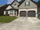 Charming two-story home featuring a two-car garage, well-maintained lawn, and attractive stone accents at 1749 Misselthrush Ln, Mcdonough, GA 30253