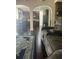 Open-concept living space showcasing wood floors, a comfortable sofa, and an archway to the kitchen at 1749 Misselthrush Ln, Mcdonough, GA 30253