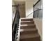 Carpeted stairway with decorative iron railing leading to the upper level of the home at 1749 Misselthrush Ln, Mcdonough, GA 30253