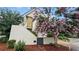 Exterior view of the home showing a side entrance and a charming tree with vibrant pink flowers at 350 Anders N, Chattahoochee Hills, GA 30268