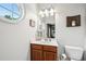 Bright bathroom with a round window, a white countertop, and cherrywood cabinets at 1858 Preserve Way, Atlanta, GA 30341