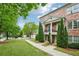 Brick townhome showcasing second story balconies, symmetrical evergreens, landscaped front yard and sidewalk entrance at 1858 Preserve Way, Atlanta, GA 30341