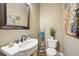 Cozy half bathroom with pedestal sink, decorative mirror, and floral artwork at 1858 Preserve Way, Atlanta, GA 30341