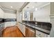 Stylish kitchen featuring stainless steel appliances, stone countertops, backsplash, white cabinetry, and wood floors at 1858 Preserve Way, Atlanta, GA 30341