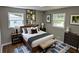 Comfortable bedroom featuring hardwood floors, two windows, decorative rug, and neutral decor at 1387 Renee Dr, Decatur, GA 30035