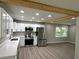 Modern kitchen with stainless steel appliances, white cabinets, and a breakfast bar at 1387 Renee Dr, Decatur, GA 30035