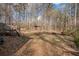 Backyard view features a deck with stairs, ample space, propane tank, and wooded backdrop, creating a private retreat at 176 Old Burnt Hickory Rd, Douglasville, GA 30134