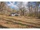 Exterior shot shows a home nestled in a serene landscape with expansive yard and mature trees at 176 Old Burnt Hickory Rd, Douglasville, GA 30134