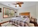 Comfortable bedroom with a queen bed, ceiling fan and two windows with natural light at 1925 Stonewyck Ct, Cumming, GA 30041