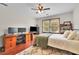 Comfortable bedroom featuring hardwood floors, a desk, two windows, ceiling fan and natural light at 1925 Stonewyck Ct, Cumming, GA 30041
