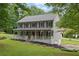 Charming two-story home with a welcoming front porch, gray siding, and classic shutters, surrounded by a lush green lawn at 1925 Stonewyck Ct, Cumming, GA 30041