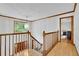 Bright hallway with wooden railing, a staircase, a light fixture, and a view of the front door and a bedroom at 1925 Stonewyck Ct, Cumming, GA 30041