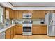 Functional kitchen with oak cabinets, granite countertops, stainless steel appliances, and hardwood floors at 1925 Stonewyck Ct, Cumming, GA 30041