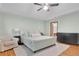 Spacious main bedroom featuring a large bed, hardwood floors, and a ceiling fan for added comfort at 1925 Stonewyck Ct, Cumming, GA 30041