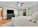 Main bedroom showcasing a large bed, hardwood floors, windows, and a ceiling fan at 1925 Stonewyck Ct, Cumming, GA 30041