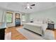Main bedroom with a large bed, hardwood floors, two windows, and a ceiling fan for comfort at 1925 Stonewyck Ct, Cumming, GA 30041