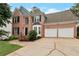Two-story brick home featuring a two-car garage and landscaped front yard with a concrete driveway at 2157 Brandon Lee Sw Dr, Marietta, GA 30008