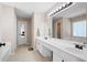 Bright bathroom with double sink vanity, large mirror, and tiled floors, blending style and functionality at 3519 Wellsley Dr, Powder Springs, GA 30127