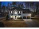 Charming two-story white brick home with a well-manicured lawn and a two-car garage at dusk at 3519 Wellsley Dr, Powder Springs, GA 30127