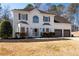 Two-story home with white brick, well-manicured lawn, and long driveway leading to a two-car garage at 3519 Wellsley Dr, Powder Springs, GA 30127