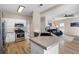 Bright kitchen with stainless steel appliances, white cabinets, and view to living area at 3519 Wellsley Dr, Powder Springs, GA 30127