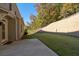 Well-maintained backyard features a patio and lush green lawn, complemented by a stacked stone retaining wall at 410 Ward Farm Dr, Powder Springs, GA 30127