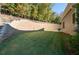 Spacious backyard with a stacked retaining wall and lush lawn providing a serene outdoor setting at 410 Ward Farm Dr, Powder Springs, GA 30127