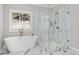 Luxurious bathroom features a soaking tub and walk-in shower with marble tile and stylish fixtures at 410 Ward Farm Dr, Powder Springs, GA 30127