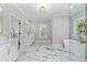 Bright bathroom with double vanities, soaking tub, separate shower, marble floors and natural light at 410 Ward Farm Dr, Powder Springs, GA 30127