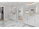 Large bathroom with double vanity, marble floors, and entry to walk-in closet and shower and tub area at 410 Ward Farm Dr, Powder Springs, GA 30127
