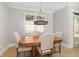 Cozy dining room with a wooden table, four chairs, a modern chandelier, and natural light at 410 Ward Farm Dr, Powder Springs, GA 30127