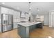 Modern kitchen with stainless steel appliances, large island, pendant lighting, and direct access to the dining area at 410 Ward Farm Dr, Powder Springs, GA 30127