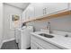 Bright laundry room featuring modern washer and dryer, basin sink and white cabinets at 410 Ward Farm Dr, Powder Springs, GA 30127