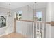 Staircase with white railing, wood steps, and pendant lights, offering a bright and open transition at 410 Ward Farm Dr, Powder Springs, GA 30127