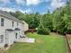 Expansive backyard with lush green grass, mature trees, and a cozy patio area at 7104 Secret Rose, Douglasville, GA 30134