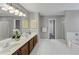 A large bathroom with dual sinks, a tub, shower, and a large mirror at 7104 Secret Rose, Douglasville, GA 30134