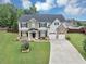 Charming two-story home with a well-manicured front lawn, driveway, and a two-car garage at 7104 Secret Rose, Douglasville, GA 30134