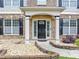 Inviting front entry with black door, white pillars and manicured landscaping at 7104 Secret Rose, Douglasville, GA 30134