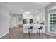 Bright kitchen features white cabinets, stainless steel appliances, island with seating, and wood floors at 7104 Secret Rose, Douglasville, GA 30134