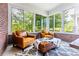 Sunroom featuring brick walls, large windows, two leather chairs, an ottoman, and a patterned rug at 937 Rosedale Ne Rd, Atlanta, GA 30306