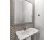 Stylish powder room featuring a pedestal sink and decorative wallpaper at 635 Broadview Ne Pl, Atlanta, GA 30324