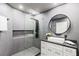 Modern bathroom featuring a glass shower, sleek vanity, and round mirror at 8610 Sentinae Chase Dr, Roswell, GA 30076