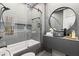 Modern bathroom featuring a sleek vanity, round mirror, walk-in shower with glass door and contemporary fixtures at 8610 Sentinae Chase Dr, Roswell, GA 30076