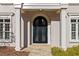 Elegant front entrance with arched doorway, detailed glass doors and stone walkway at 8610 Sentinae Chase Dr, Roswell, GA 30076