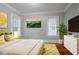 A staged bedroom with hardwood floors, natural paint, and bright sunlight at 1615 Stokes Sw Ave, Atlanta, GA 30310