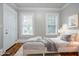 Virtually staged bedroom featuring hardwood floors, two windows, and stylish decor at 1615 Stokes Sw Ave, Atlanta, GA 30310