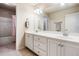 This is a well-lit bathroom that boasts a dual vanity, large mirror, and a shower-tub combo at 1898 Alcovy Shoals Se Blf, Lawrenceville, GA 30045