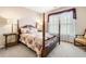 Cozy bedroom with a four-poster bed, side tables, and a sun-filled window at 1898 Alcovy Shoals Se Blf, Lawrenceville, GA 30045