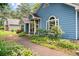 Landscaped walkway leading to a charming blue single-story home and well-maintained yard at 2395 Holly Branch Dr, Cumming, GA 30040